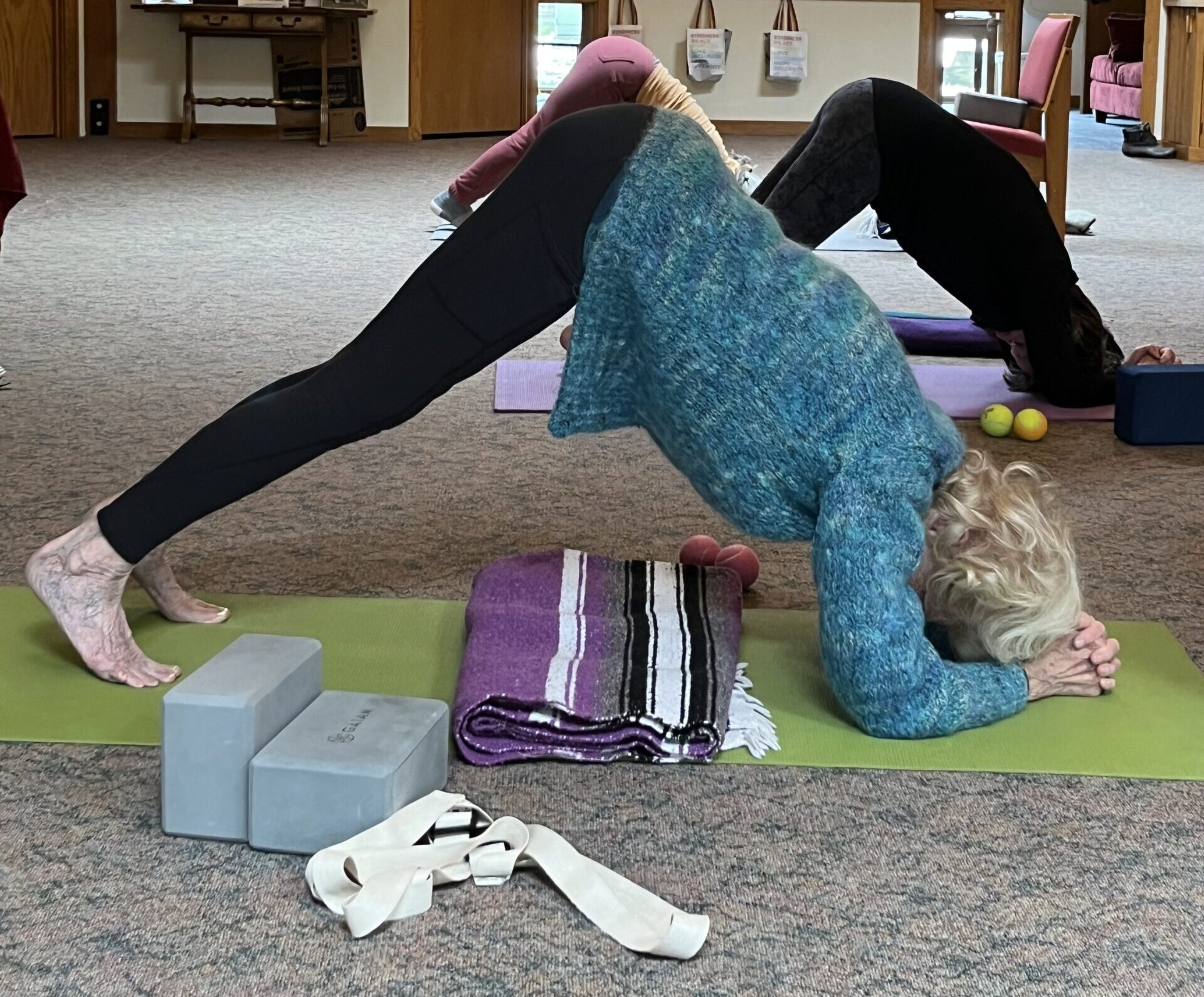 silver sneaker yoga student doing therapeutic yoga in dolphin yoga